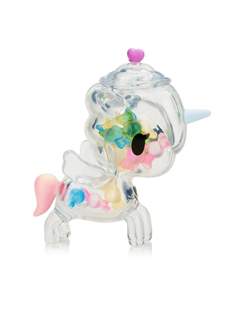 A tokidoki Sugar Shop Unicorno Blind Box figure—clear plastic with a blue horn, pink tail, and pastel beads inside—is seen in profile against a white background.