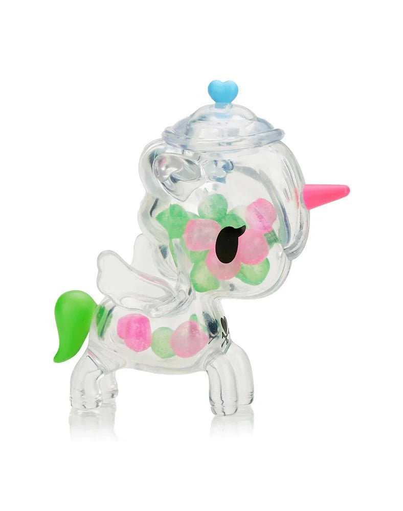 Tokidoki Sugar Shop Unicorno Blind Box by tokidoki features a clear plastic figurine with green and pink spots, a pink horn, white wings, green tail, and blue heart—an adorable candy collectible from the popular series.