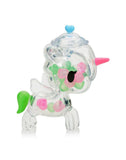 Tokidoki Sugar Shop Unicorno Blind Box by tokidoki features a clear plastic figurine with green and pink spots, a pink horn, white wings, green tail, and blue heart—an adorable candy collectible from the popular series.