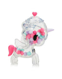 The tokidoki Sugar Shop Unicorno Blind Box features a clear plastic unicorn with a pink tail, purple horn, and heart-shaped lid filled with colorful beads—an adorable candy collectible for any unicorn lover.
