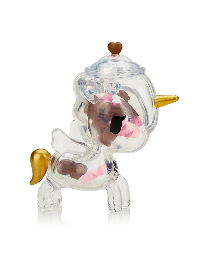 The tokidoki Sugar Shop Unicorno Blind Box features a clear plastic figurine with a gold horn and tail, white wings, pink and brown accents, and a heart-shaped knob—an adorable collectible from tokidoki.