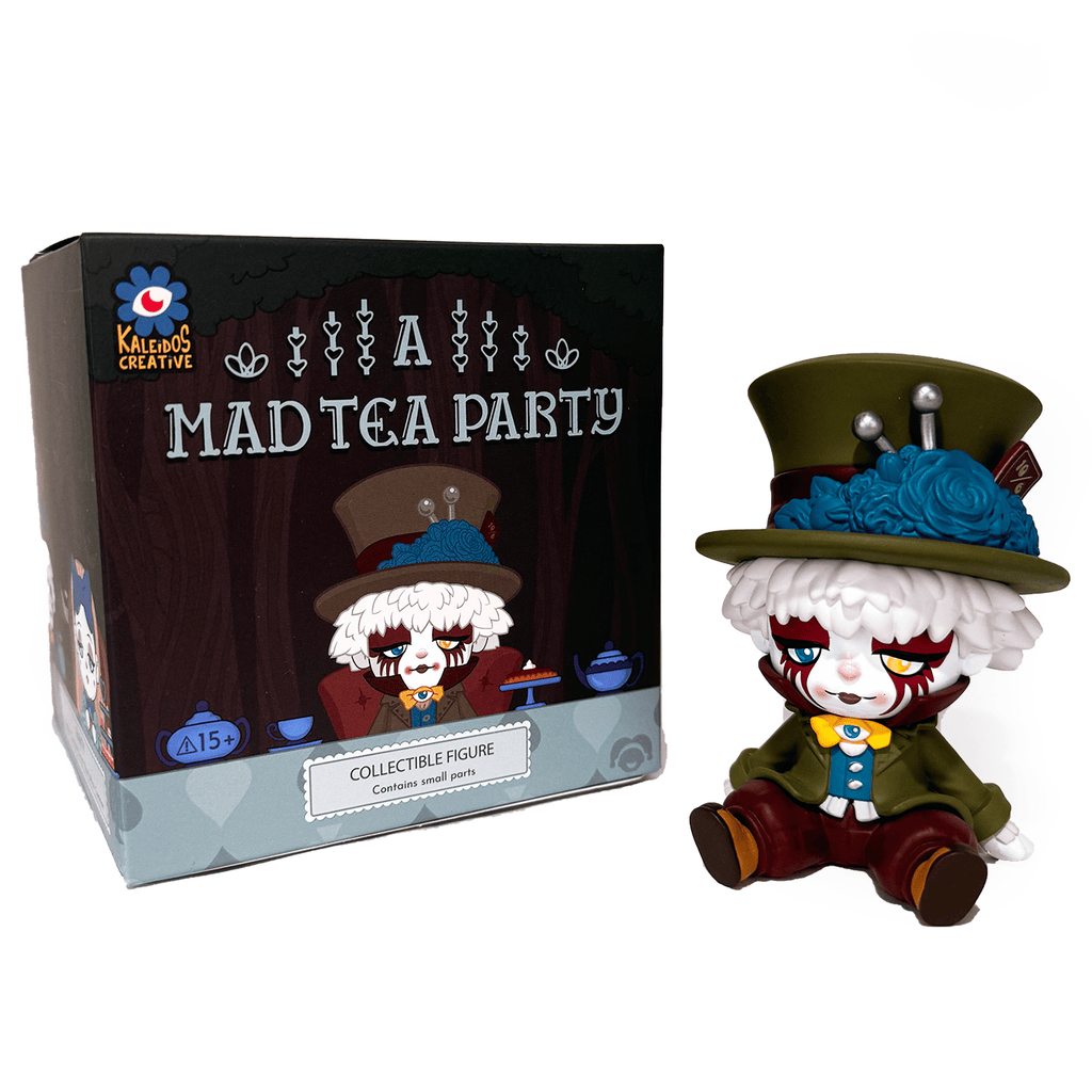 A whimsical collectible with white hair, a green jacket, and a large green hat sits beside Kaleidos Creative's