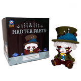 A whimsical collectible with white hair, a green jacket, and a large green hat sits beside Kaleidos Creative's