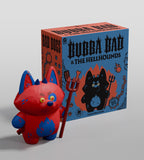 A red and blue cat-like devil dog toy holding a trident stands before a box labeled
