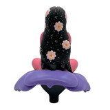 Flower Girl by UVD Toys is a collectible figure featuring a seated character with long black hair, decorated with flowers and stars, resting on a large purple flower—perfect for collectors.