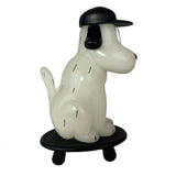The One-Chu SK8 - Glow by How2Work features a stylized white dog with black ears and cap on a black skateboard, complete with glow-in-the-dark details.