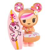 A tokidoki Hawaiian Ohana Blind Box figure with pink hair and a flower lei stands by a unicorn and heart-adorned surfboard, bringing tropical collectible charm from the tokidoki brand.
