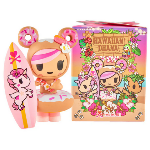 A kawaii donut-themed figurine with a pink surfboard stands by the tokidoki Hawaiian Ohana Blind Box, which features vibrant character art and floral designs—perfect for fans of tropical collectibles.