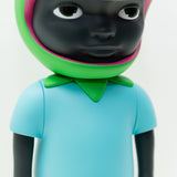 Phibby — OG (Green) by Hebru Brand is a 12-inch collectible vinyl figurine with dark skin, a light blue shirt, and a vibrant green and pink helmet shaped like a flower or fruit, inspired by Hebru Brantley’s limited edition art.