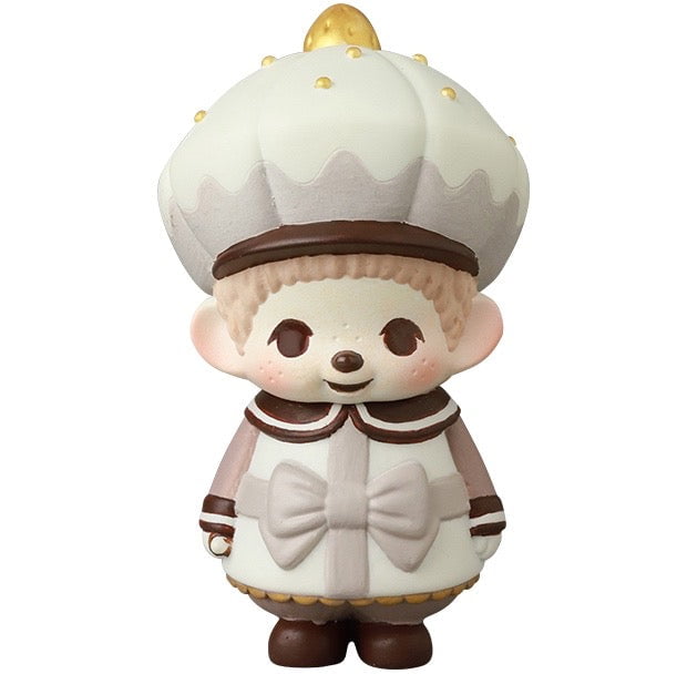 The VAG 45 — Monchhichi Happy Gift Box by Medicom features a charming gachapon figure of a child in a white and brown outfit with a round, gold-dotted hat, standing and smiling.