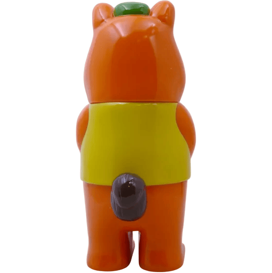 The Mamechan - #1 plastic bear figurine by Paradise Toy wears a green hat, yellow vest, and has a gray tail. Facing away on a white background, this adorable collectible is perfect for fans of cute travel-themed toys.