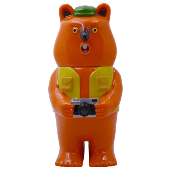 Mamechan - #1 by Paradise Toy: a plastic bear figurine standing upright, wearing a green hat and yellow vest, holding a camera with a surprised look—an ideal tourist collectible for your collection.