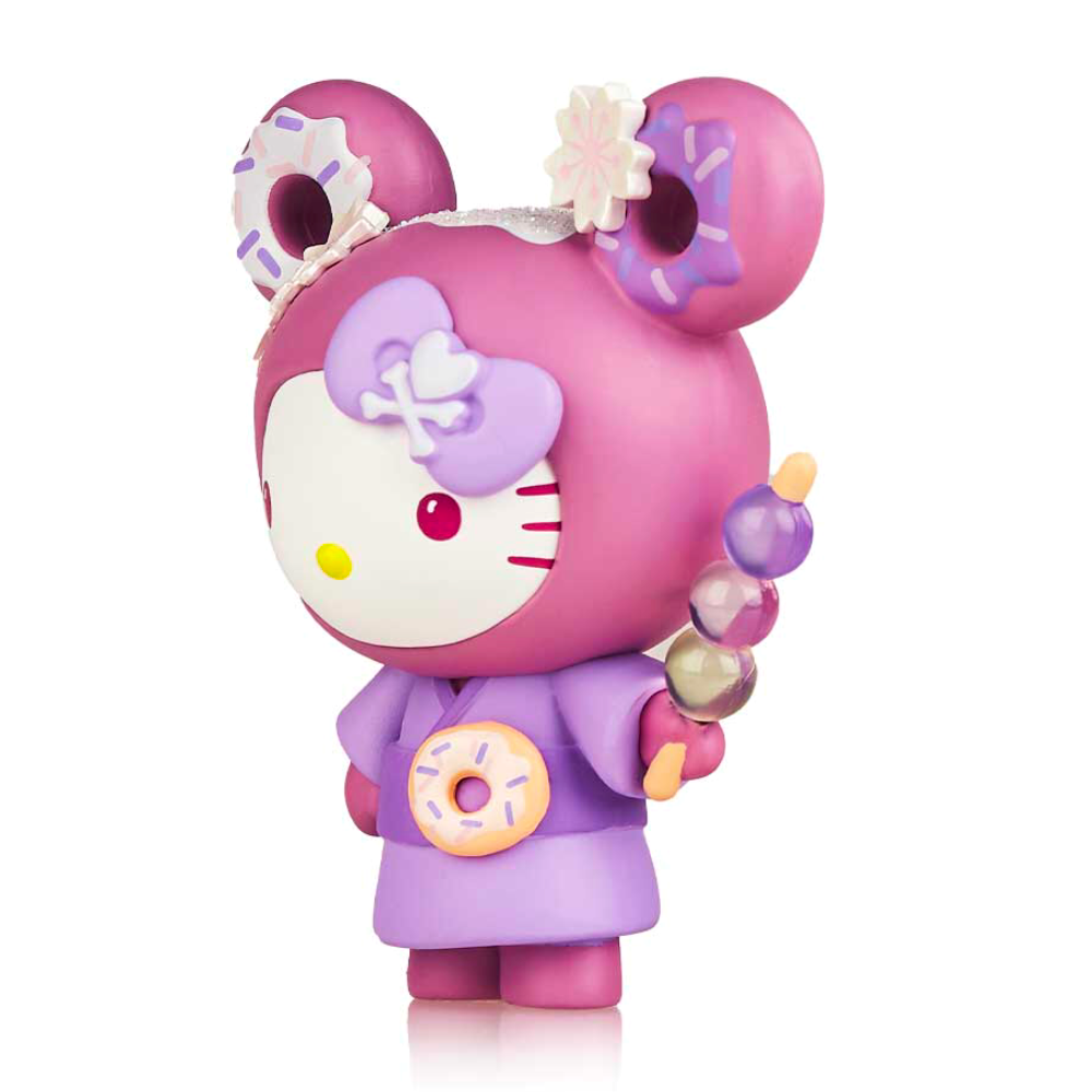 A pink Hello Kitty figure from the limited edition Tokidoki x Hello Kitty Series 3 by tokidoki, wears a purple kimono with donut motifs and holds a skewer with pastel treats, including ube-inspired delights.