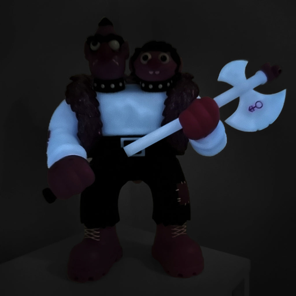 Bernie — Purple Reign Rotofugi Exclusive by UFO Toys is a sofubi figure with two heads, white shirt, black pants, and a glowing axe—an eye-catching glow in the dark collectible for toy fans.