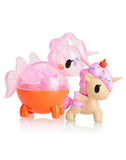 Two small, colorful toy figures: a translucent pink and orange winged creature and a tokidoki Unicorno with cupcake-themed design and sprinkles from the Unicorno Capsule Cuties Blind Box series.