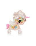 The Toki Mochi Donut Unicorno Blind Bag by tokidoki features a clear unicorn with a pink horn and tail, filled with colorful sprinkles—ideal for fans of squishy Unicornos or collectors of the Donut Unicorno Blind Box series.
