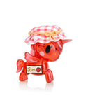 A red, translucent Unicorno figurine from the Toki Mochi Donut Unicorno Blind Bag by tokidoki, labeled