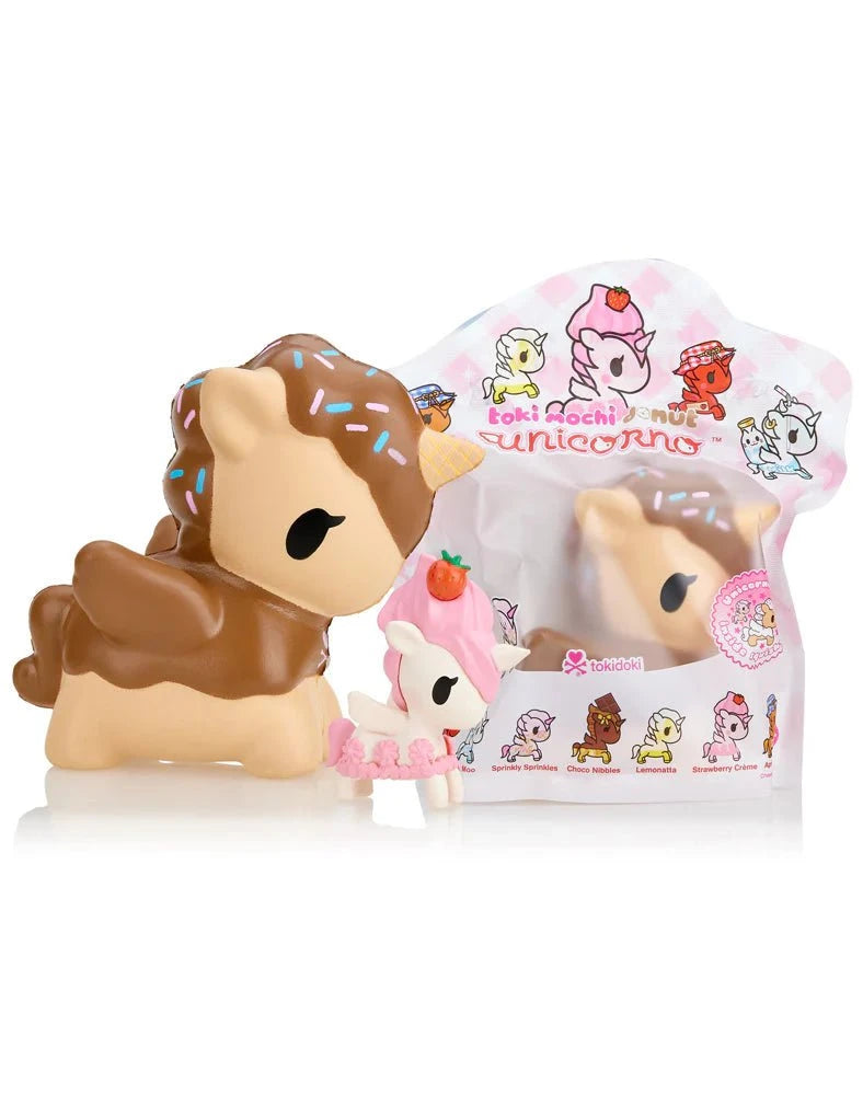 Two brown and pink unicorn figurines are shown in front of vibrant packaging with