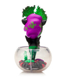 The tokidoki Neon Reef Mermicorno - Deep Star Coral Special Edition features a figurine with purple and green hair in a clear fishbowl, standing on black, red, and purple pebbles, plus glow-in-the-dark accents.