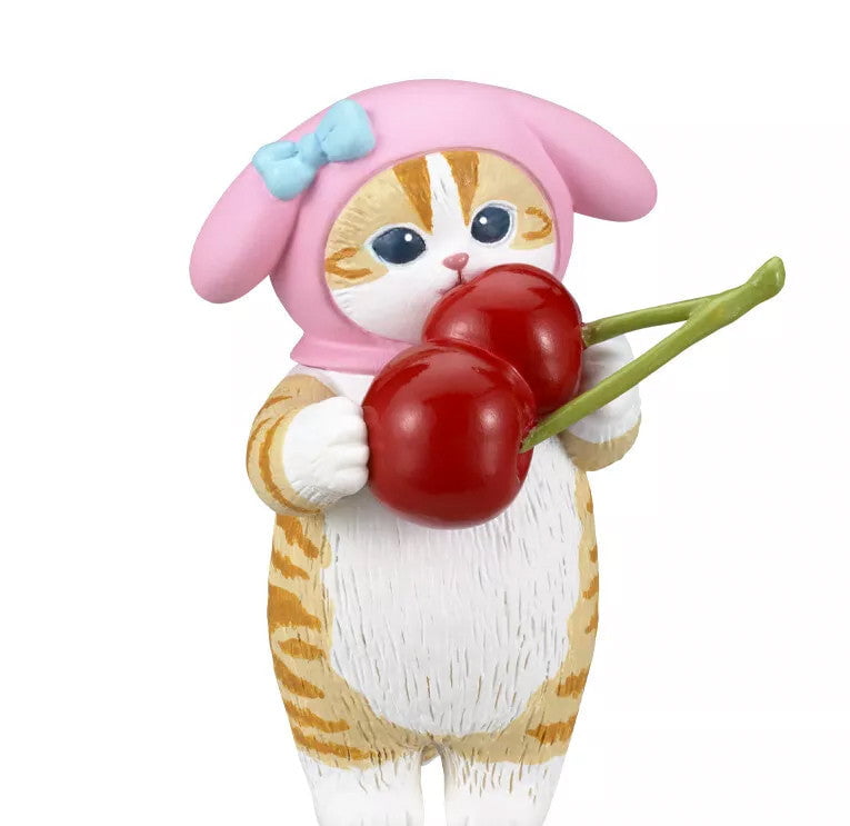A small Mofusand x Sanrio Series 2 Capsule figurine by Kitan Club, featuring an orange and white cat in a pink hood with a blue bow, wearing a cute costume and holding two large red cherries.
