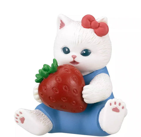 A Mofusand x Sanrio Series 2 Capsule figurine from Kitan Club features a white cat in a blue outfit with a red bow, holding a large strawberry.