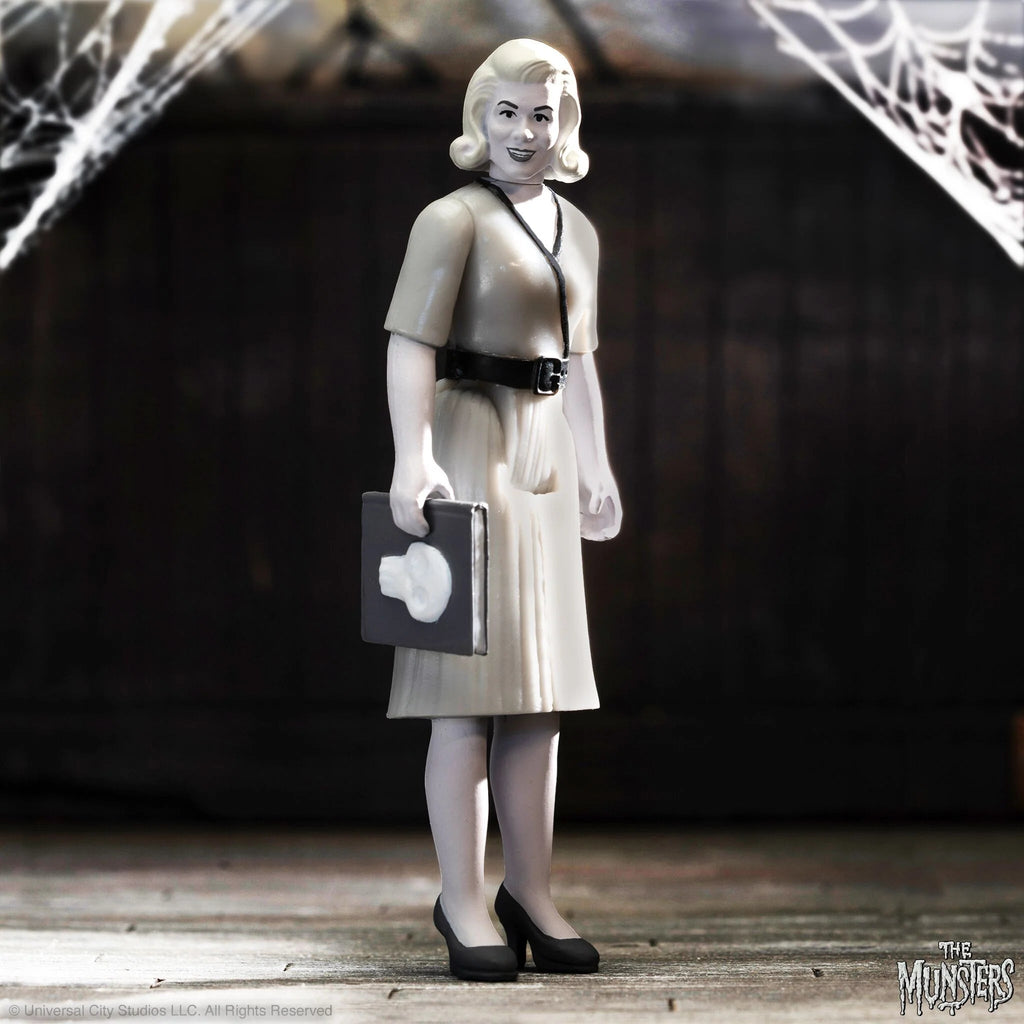 The Super7 The Munsters ReAction - Marilyn grayscale figure stands in a dress with a briefcase against spiderwebs,