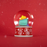 The 100% Soft Dumpster Fire Snow Globe features a mini green dumpster with colorful trash on a red base and falling snow—perfect quirky desk decor for the season.