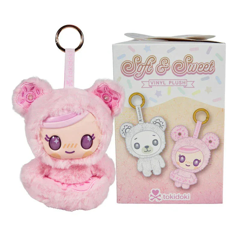 A pink tokidoki plush keychain with a doll face and bear ears sits beside its Tokidoki Soft & Sweet Vinyl Plush Blind Box, which features the words