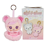 A pink tokidoki plush keychain with a doll face and bear ears sits beside its Tokidoki Soft & Sweet Vinyl Plush Blind Box, which features the words