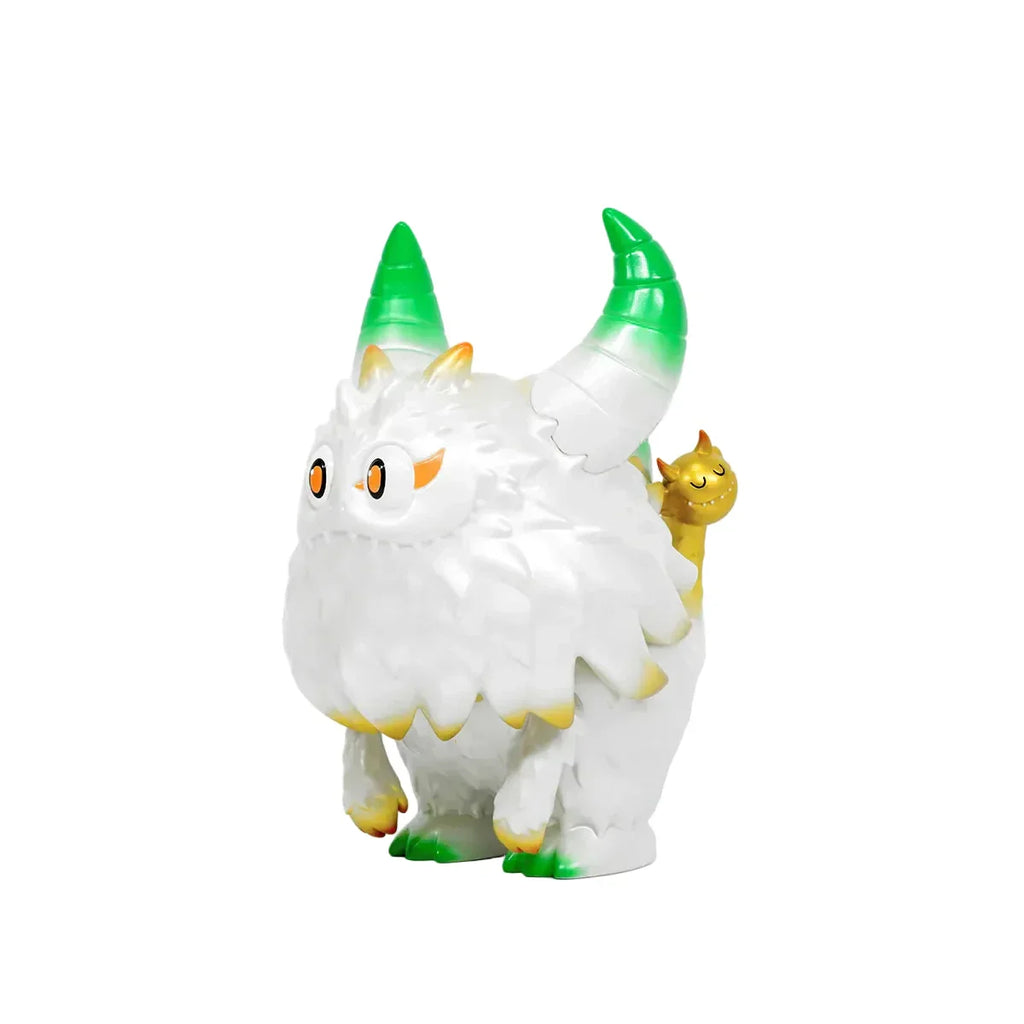 The Little Hut’s Rangeas Rex Jr. — White & Gold collectible toy features a white, furry creature with green-tipped horns and a small brown animal on its back, displayed against a plain white background.
