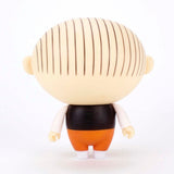 The Presspop Jimmy Corrigan Vital Animus Vinyl Doll is shown from the back, featuring a round head with vertical brown hair stripes, black shirt, orange pants, and white shoes against a white background.