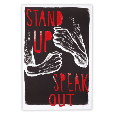 Black and white illustration of raised arms with bold red "STAND UP SPEAK OUT" text on a dark background. "Stand Up, Speak Out by JUDGE" embodies striking screenprint style from the brand JUDGE.