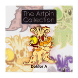 The Artpin Collection - Mandrake Root by Doktor A features a cartoonish, orange, tentacled creature on a pin backing labeled