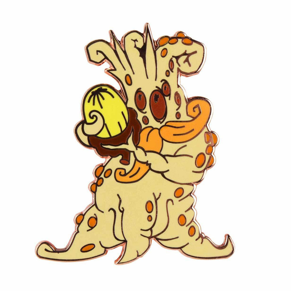 A cartoonish creature with orange spots holds a yellow Mandrake Root pin by Doktor A in its left hand, wearing an orange scarf, against a white background—a whimsical piece from The Artpin Collection.