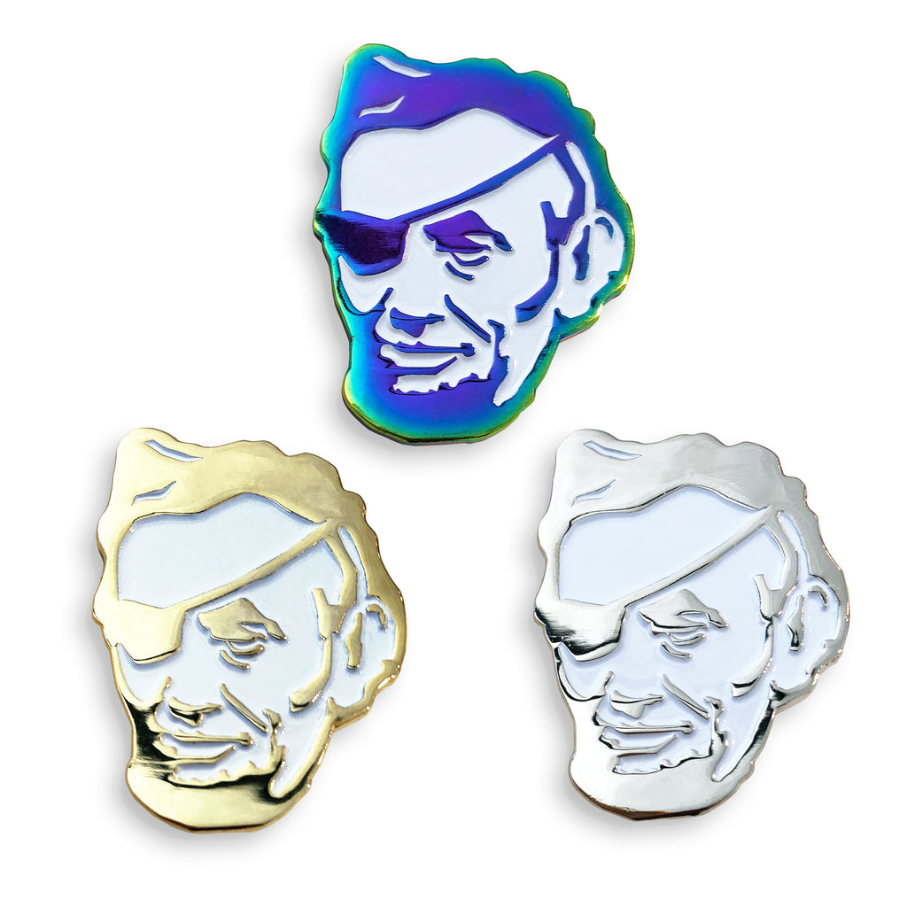 The Rotofugi Pirate Abe Enamel Pin by Rotofugi is available in gold, silver, and iridescent blue finishes—a quirky pin shaped like Abraham Lincoln with an eye patch, ideal for collectors or as a standout mascot accessory.