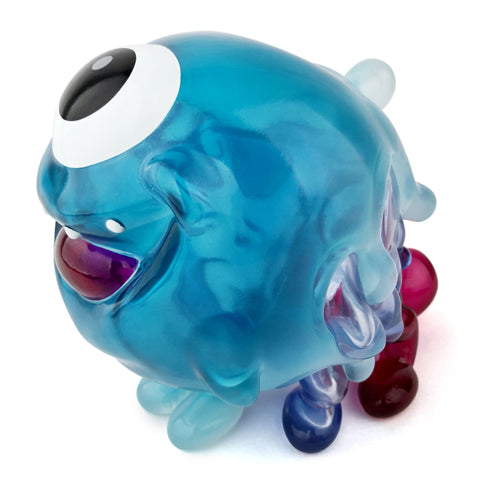 The Gellog — Type-D (Rotofugi Exclusive) by Strangecat Toys is a blue, translucent figurine with one eye, a big mouth, and colorful limbs—ideal for collectors of unique designer toys.