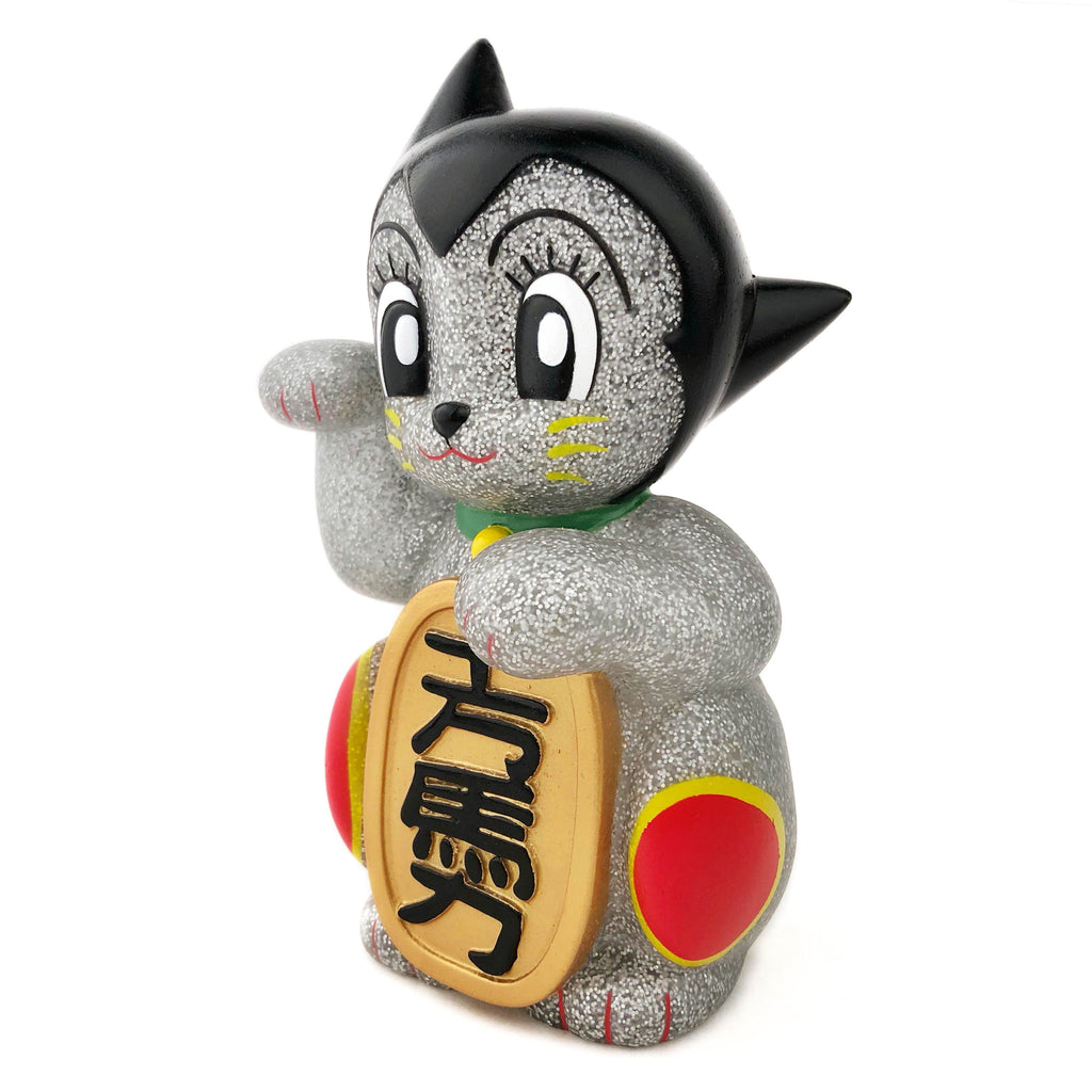 The Maneki-Astro — Silver Metallic Flake by DoomCo Designs is a Rotofugi exclusive cat figurine with large eyes, black hair, and a gold coin with Japanese characters, raising one paw in a beckoning gesture.