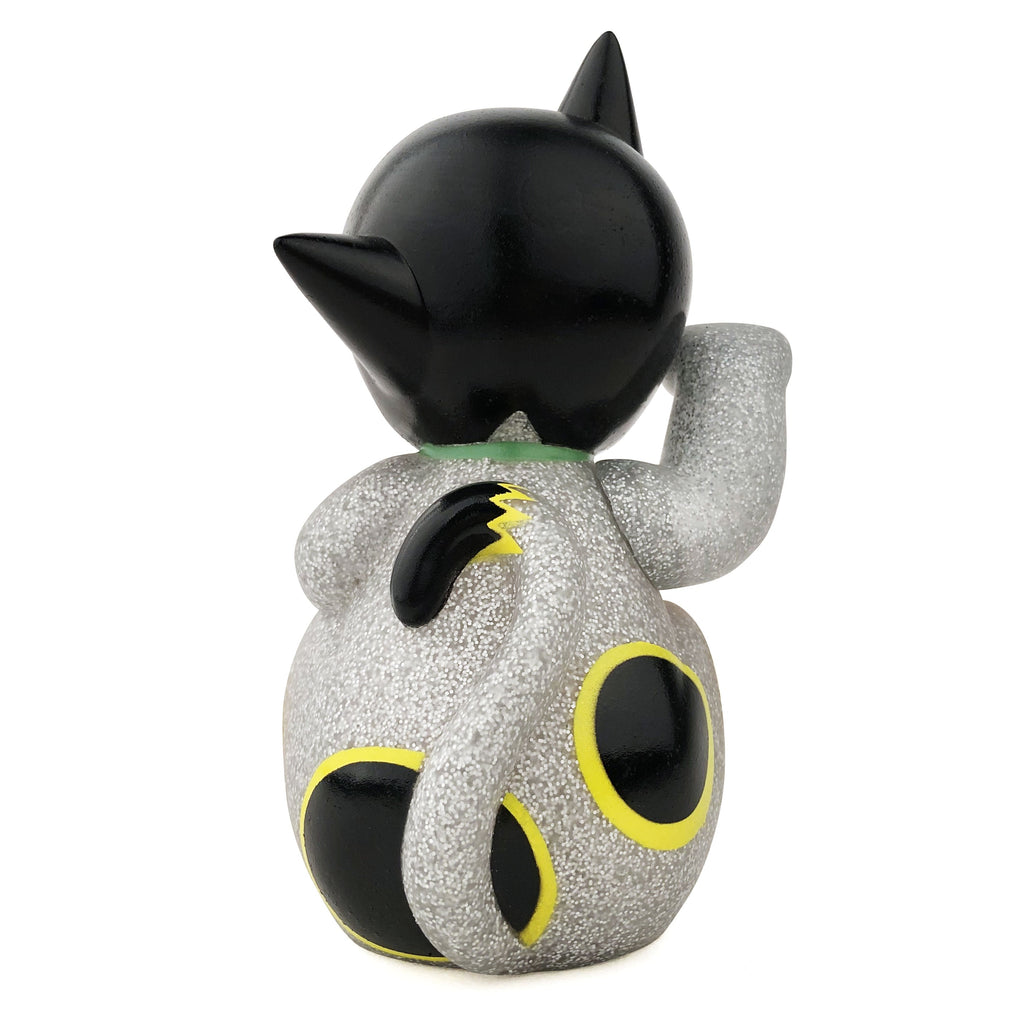 The Maneki-Astro — Silver Metallic Flake by DoomCo Designs, a Rotofugi Exclusive, is a small collectible cat figurine with glittery silver finish, black ears and tail, plus yellow-rimmed circles on its back and tail.