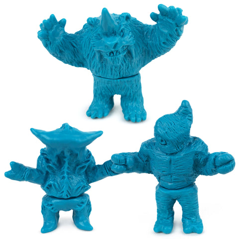 Three blue plastic toy monsters with exaggerated features stand upright—two in front and one behind with raised arms. This is the Geoff Maxfield Neo-Fighters X Rotofugi 312 Edition figure.
