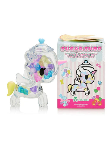 A clear unicorn-shaped candy collectible with colorful beads stands next to its pastel Blind Box labeled "Tokidoki Sugar Shop Unicorno Blind Box" from tokidoki.