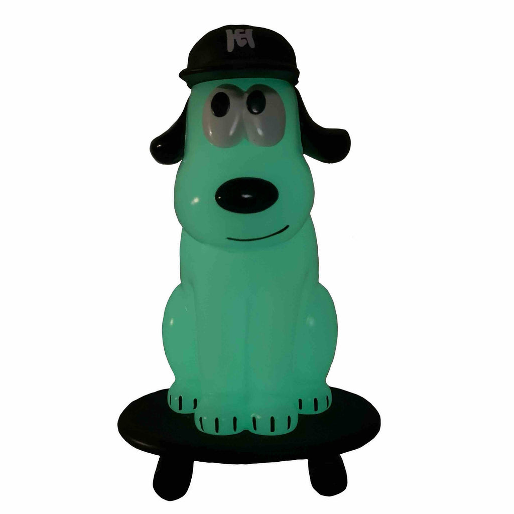 The One-Chu SK8 - Glow by How2Work features a green cartoon dog figure in a black cap sitting on a skateboard-like black platform, set against a white background.