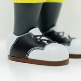 Close-up of Hebru Brand's limited edition Phibby — OG (Green), a 12-inch collectible vinyl featuring black and white shoes with brown soles and yellow pants, inspired by Hebru Brantley's iconic style.