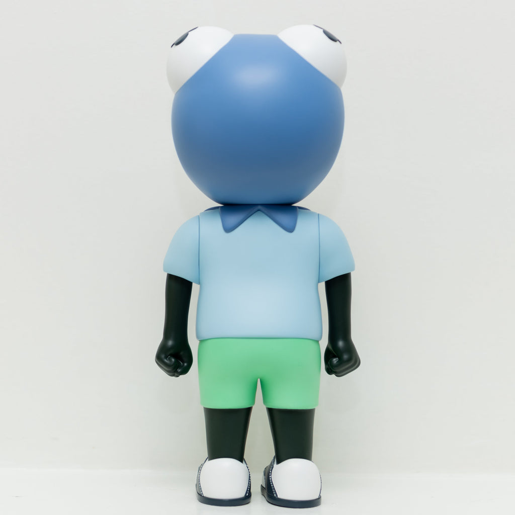Phibby — Purple by Hebru Brand is a cartoonish frog vinyl figure with a large blue head, big white eyes, a light blue shirt, and green shorts, standing against a plain white background.
