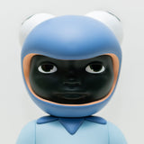 Phibby — Purple by Hebru Brand is a limited edition vinyl figure with a stylized dark face, blue outfit, and a hood shaped like a frog’s head with large eyes, inspired by Hebru Brantley’s signature style.