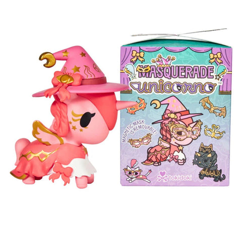 A pink unicorn figurine in a witch hat and cape stands next to a tokidoki Unicorno After Dark Masquerade Blind Box—an ideal collectible for toy enthusiasts.