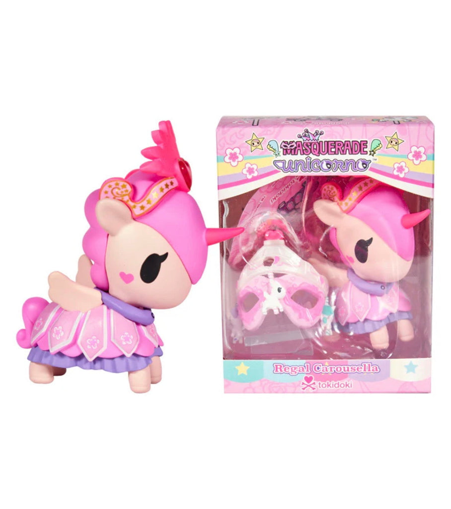 A pink and purple Unicorno After Dark Masquerade - Regal Carousella (Special Edition) toy with a crown and mask stands by its box, branded tokidoki.