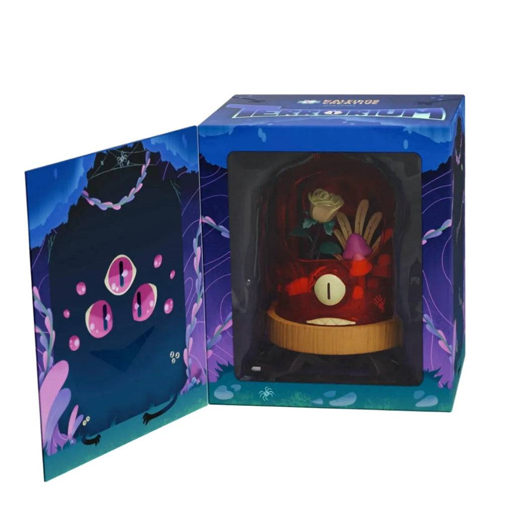 Kaleidos Creative’s Terrorium - Crab Cloche is a collectible window box figure featuring a dark forest scene with mushrooms and a creature sporting four glowing pink eyes, revealed beside an open flap in the display box.