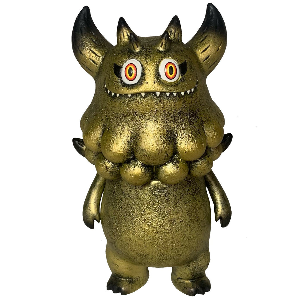 The Little Hut’s Rangeas Jr. - Gold Patina figure features gold horns, wide eyes, pointed teeth, clawed hands, and a bumpy chest—an eye-catching collectible monster standing upright against a white background.