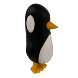 A side view of Strangecat Toys' Old Friend — Original, a black and white penguin figurine with yellow feet and beak, isolated on a white background—like an old friend ready to catch up.