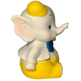 A side view of the Bitter Squeaks Yellow Bowtie Baby Elephant plush, a cartoon baby elephant wearing a yellow cap, yellow pants, white jacket, blue bow tie, and one arm raised.